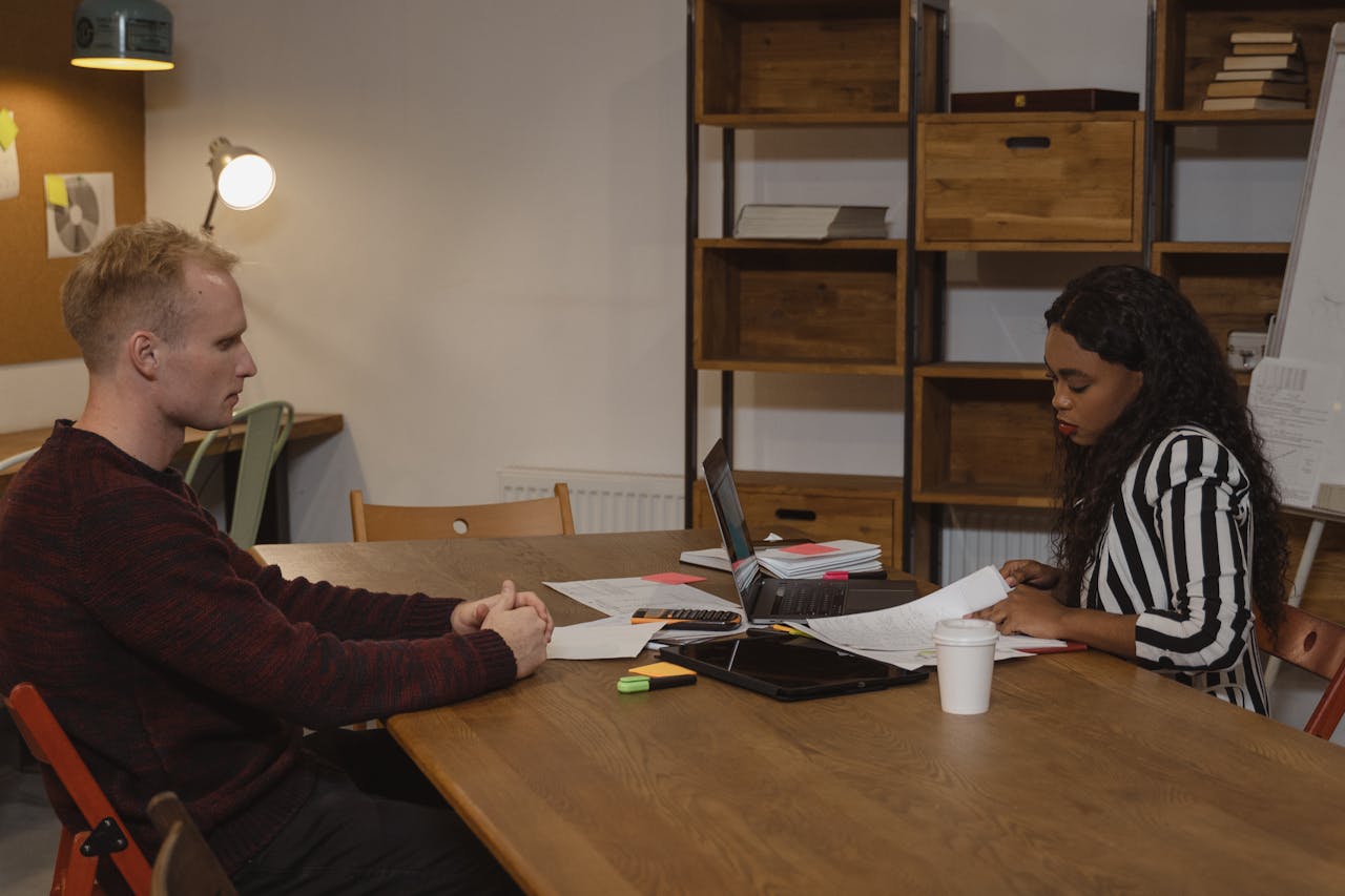 Two professionals engaged in a business meeting at a modern office, discussing strategies.